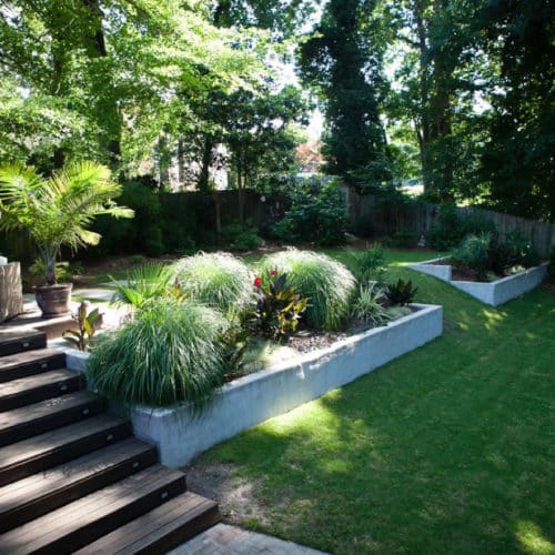 Shaded backyard lawn with terracing and lounge area