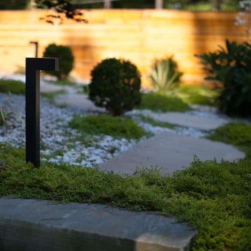 Minimalist plantings with stepping stones, gravel and landscape light