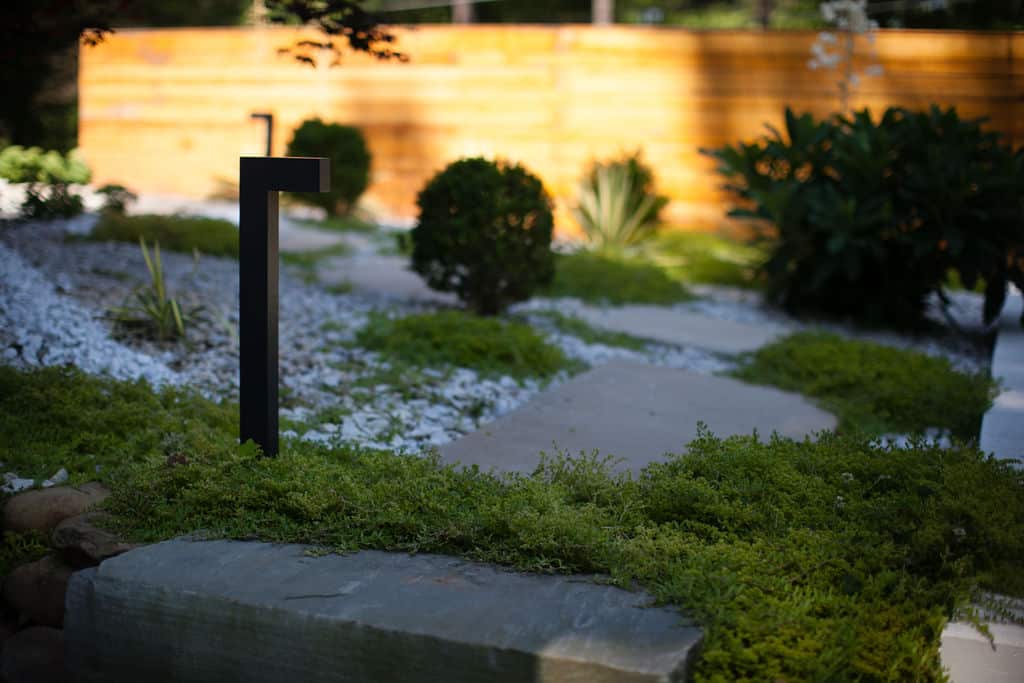 Minimalist plantings with stepping stones, gravel and landscape light