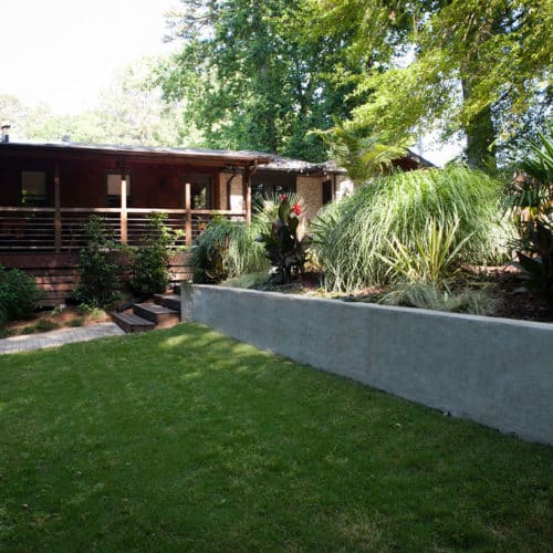 Shaded yard with raised concrete planting bed, stucco finish