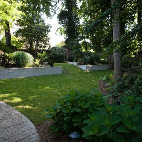 Shaded backyard with raised planting bed, lawn area