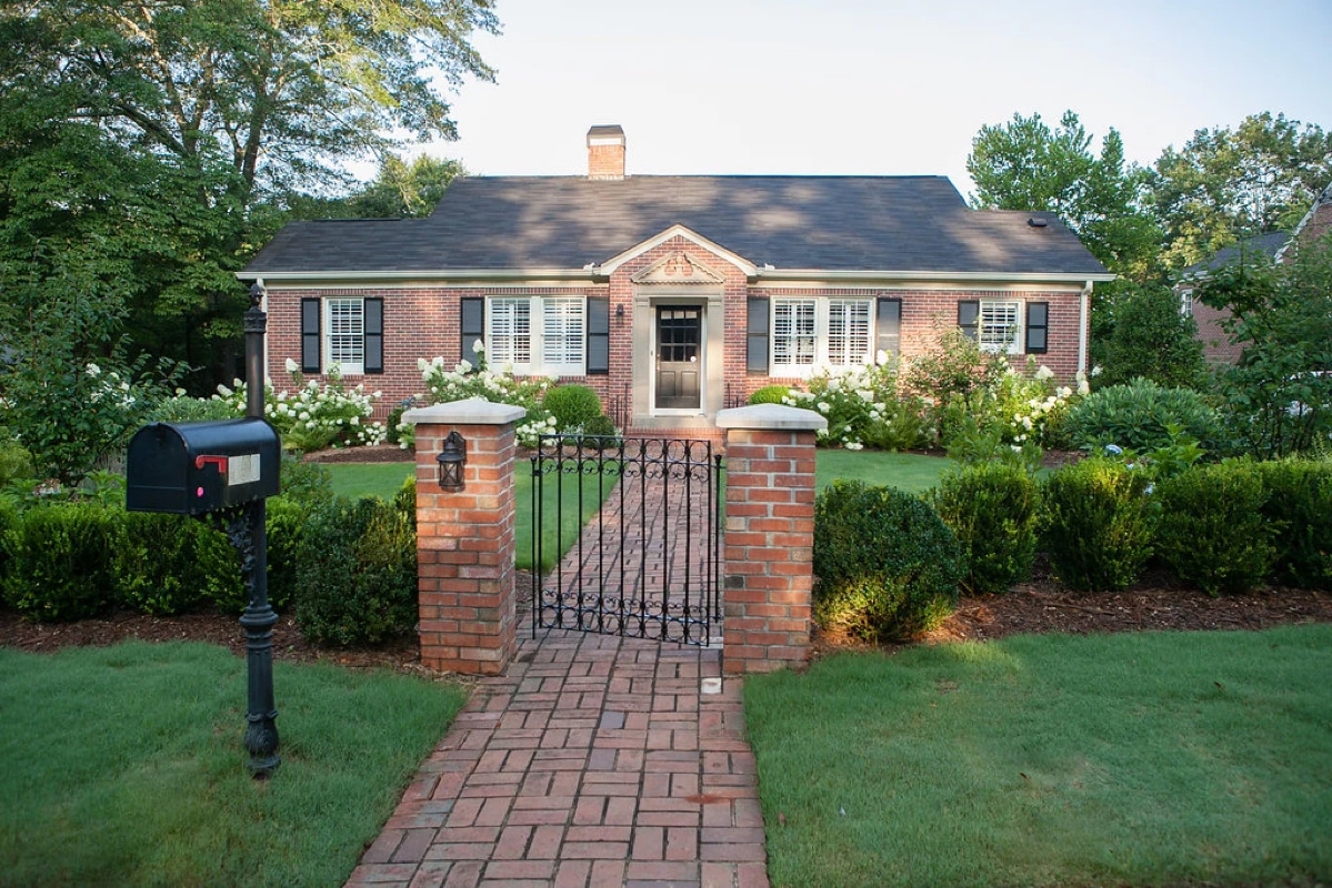 Traditional brick pathway with columns and iron gate