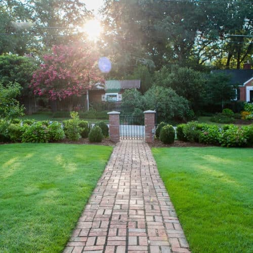 Restored brick pathway with columns and metal gate
