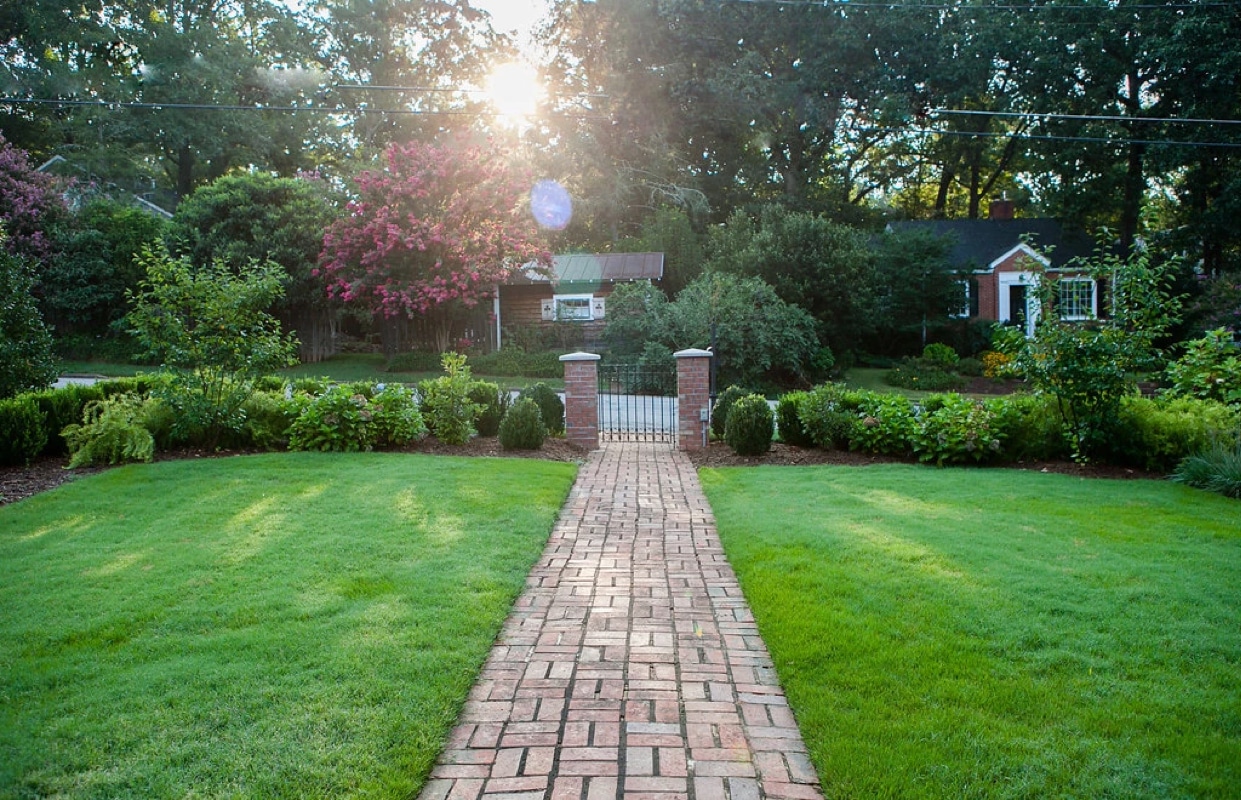 Restored brick pathway with columns and metal gate