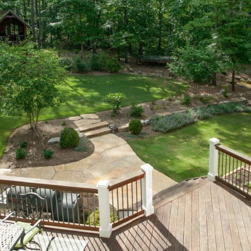 Contemporary family backyard with deck, stone path, lawn, low-maintenance plants