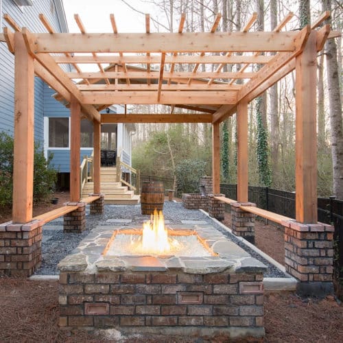 Backyard pergola with built-in seating and brick fire pit