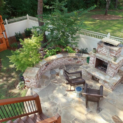 Brick and stone patio with fireplace and kids play area