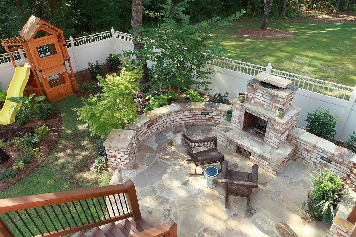 Brick and stone patio with fireplace and kids play area