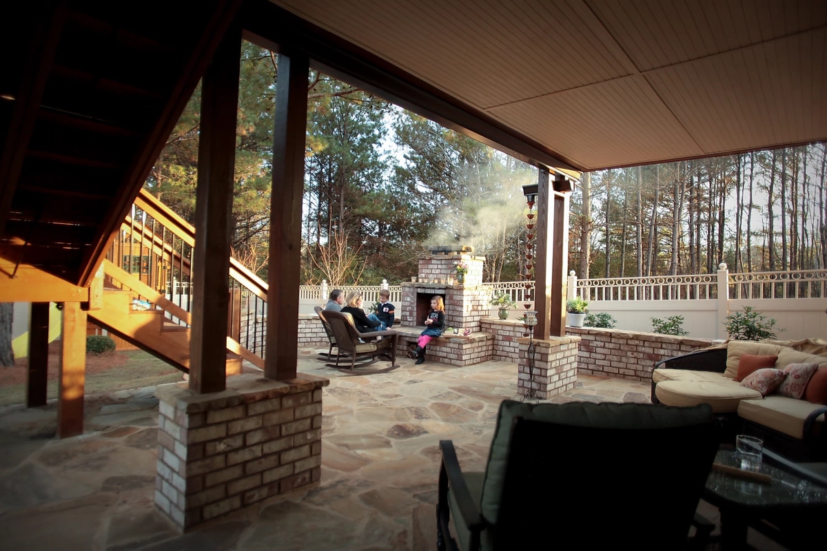 Family-friendly covered stone brick patio with fireplace