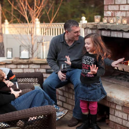 Family time in backyard patio with custom fireplace