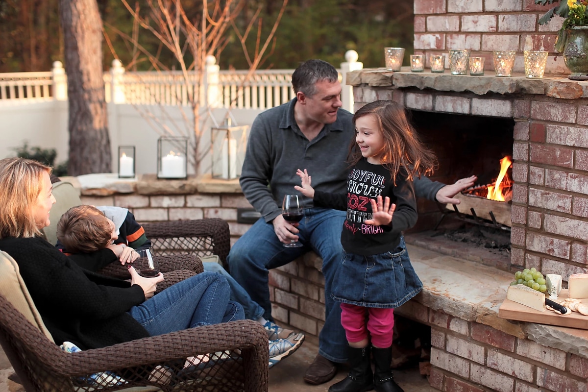 Family time in backyard patio with custom fireplace