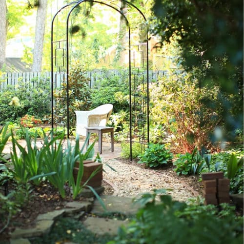 Quiet backyard space with stepping stones and metal arbor