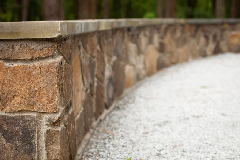 Natural stone retaining seat wall and gravel patio