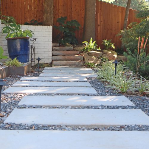 Modern poured concrete pathway panels with crushed slate gravel