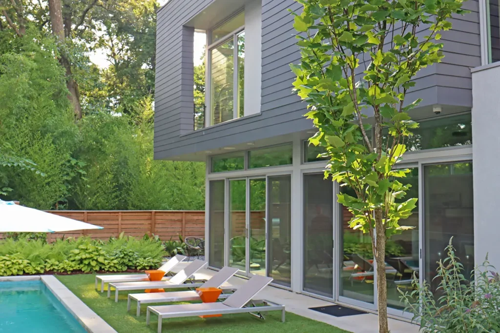Modern pool construction complemented by outdoor living space with artificial turf and concrete